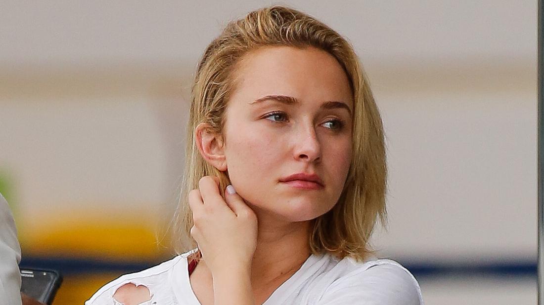 Closeup of Hayden panettiere In Ripped White T-Shirt Touching Her Neck And Looking Concerned